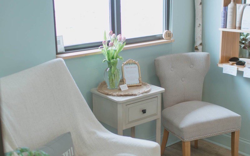 The waiting lounge at J. Jukuri Spa & Salon with soft chairs, plants and natural light