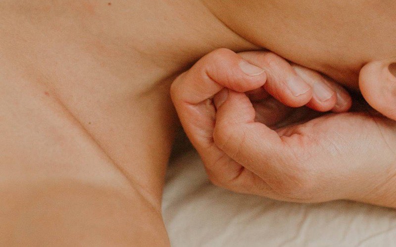 Close-up of a massage therapist's hands working into a client's shoulder